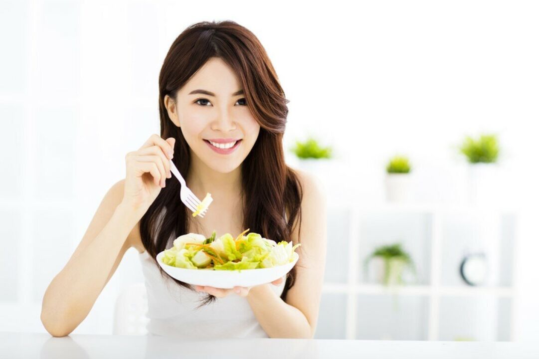 Japonų moteris valgo salotas